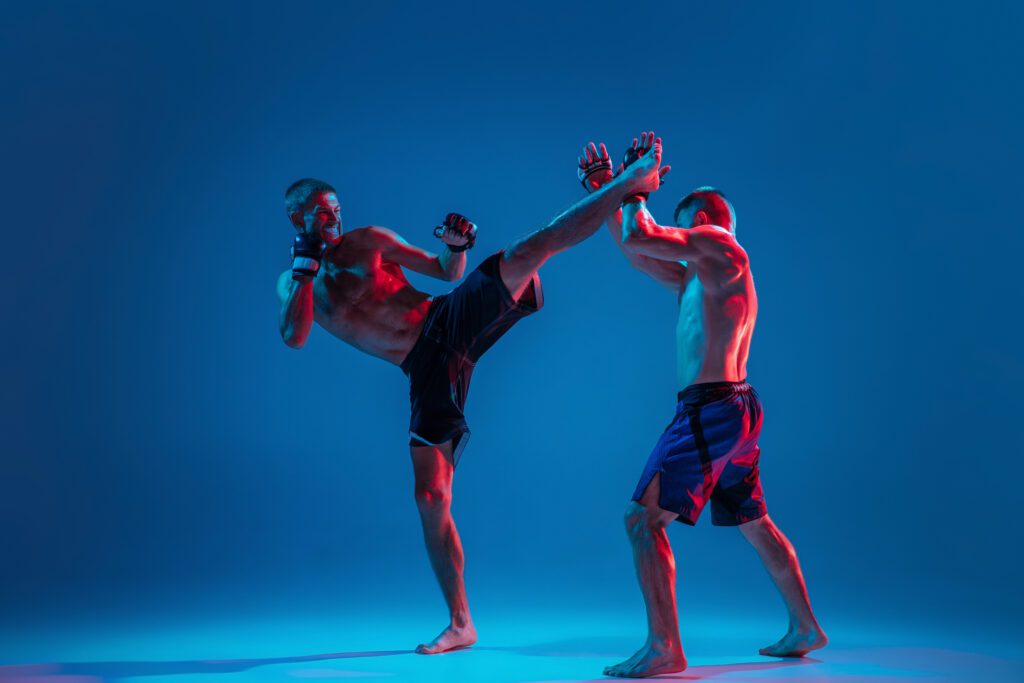 mma kick boxing near tilak nagar, delhiMMA. Two professional fighters punching or boxing isolated on blue studio background in neon