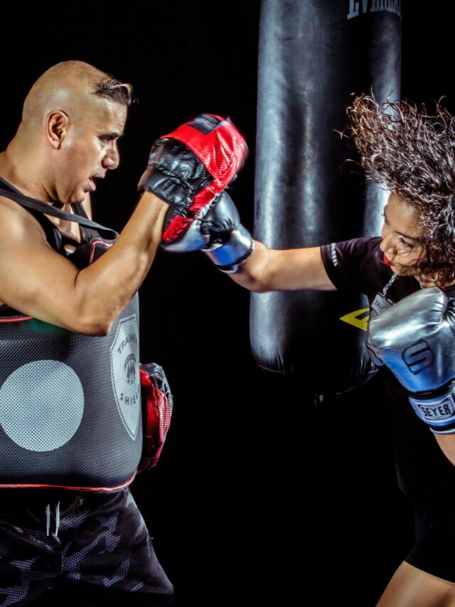 Woman Punching the Hand of Man Wearing Training Gloves